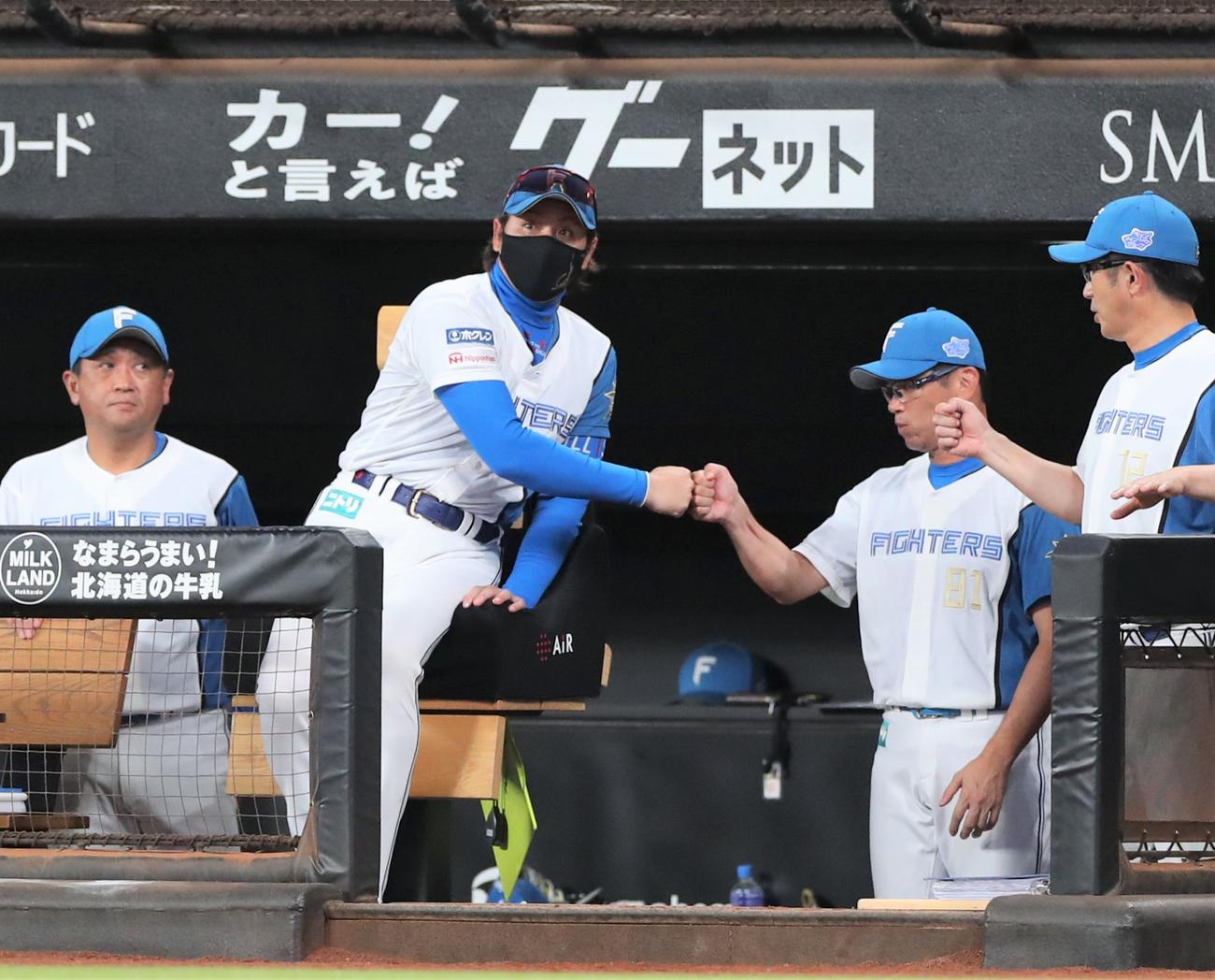 日本ハム対ロッテ　4連勝し建山投手コーチとタッチする新庄監督（撮影・黒川智章）