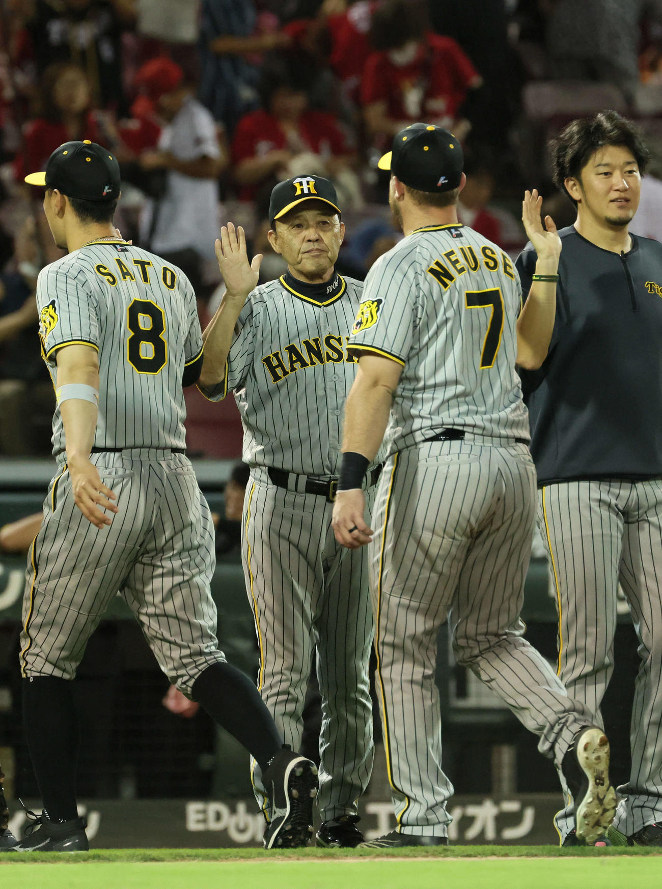 広島対阪神　広島に勝ちマジック29を点灯させた岡田監督（中央）は、佐藤輝（左）とノイジー（同3人目）を迎える。右端は岩貞（撮影・加藤孝規）