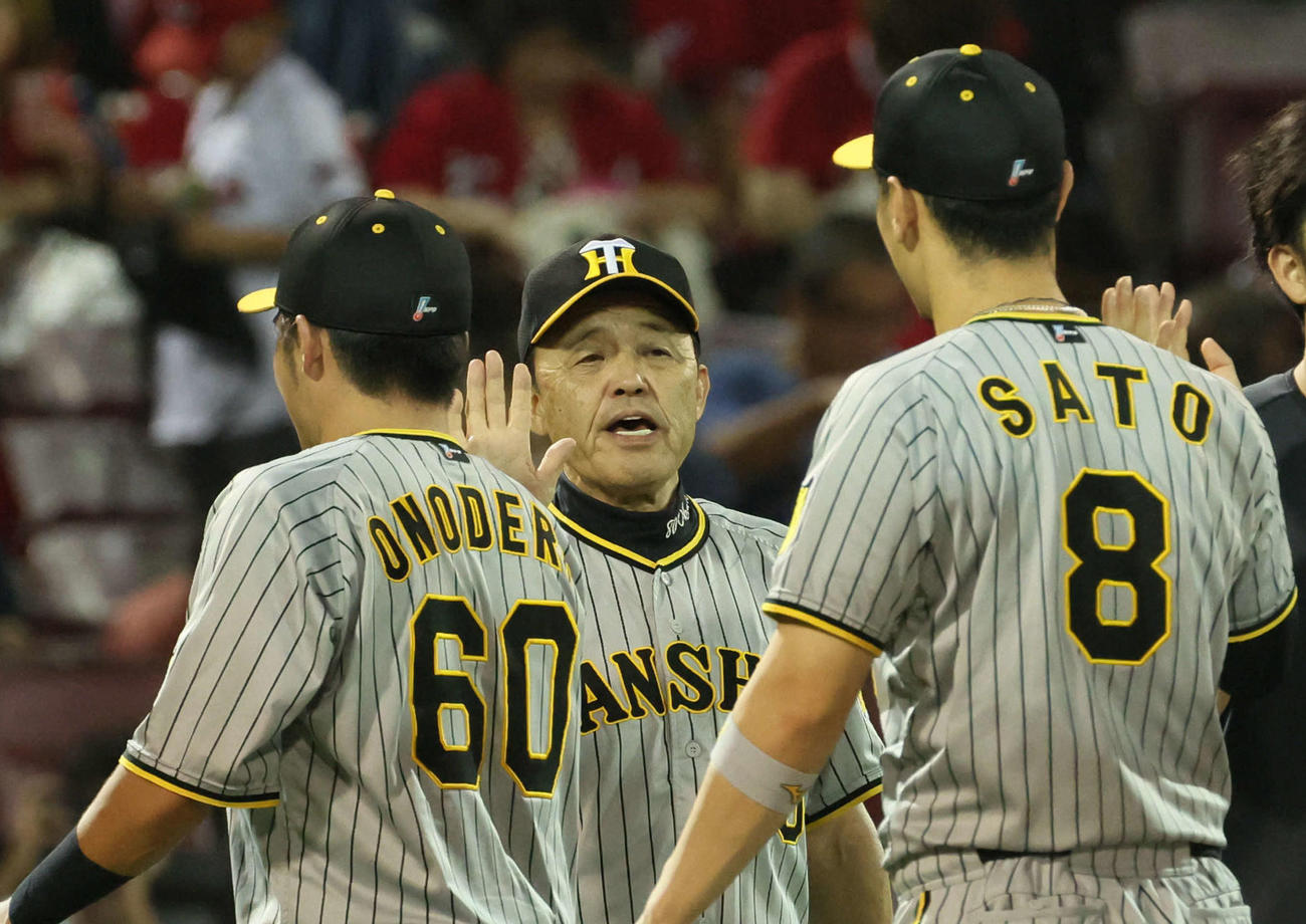 広島に勝ちマジック29を点灯させた岡田監督（中央）は、小野寺（左）と佐藤輝（右）を迎える（撮影・加藤孝規）