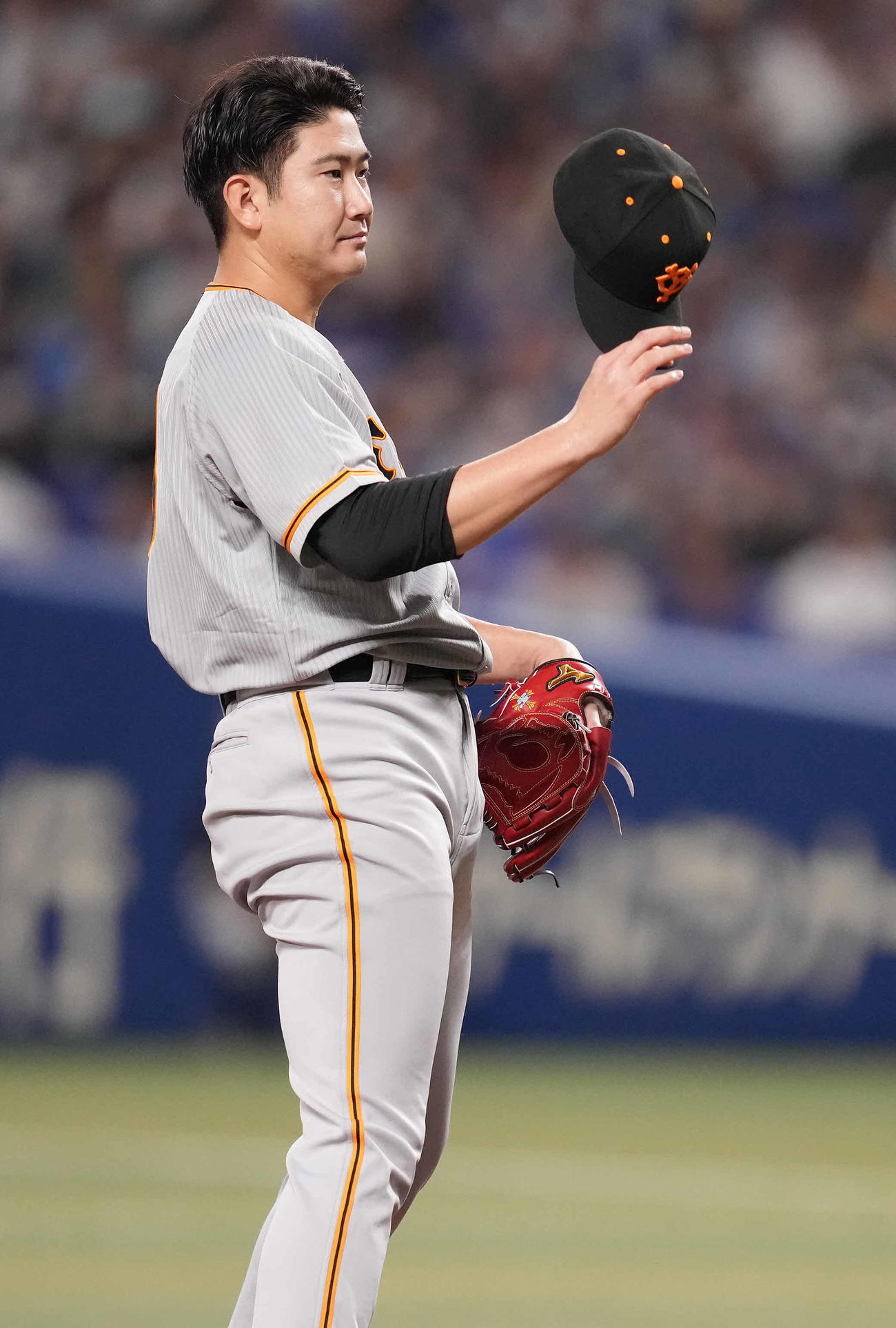 中日対巨人　7回裏中日1死一塁、代打三好に死球を与え、帽子を脱ぐ菅野（撮影・鈴木みどり）