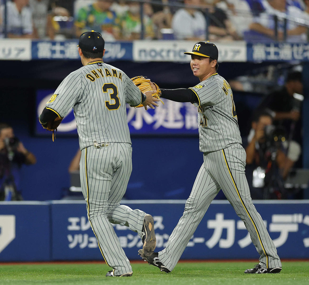DeNA対阪神　3回裏を抑え、大山(左)らナインを笑顔で迎える村上（撮影・河田真司）