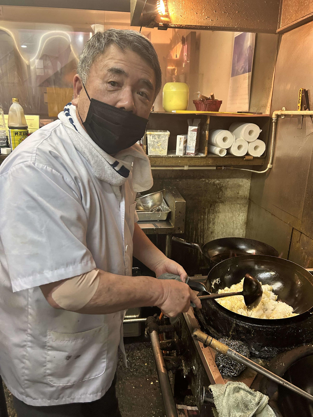 浅野からプレゼントされた中華鍋でチャーハンを炒める「えびす屋」の吉田誠さん（撮影・上田悠太）