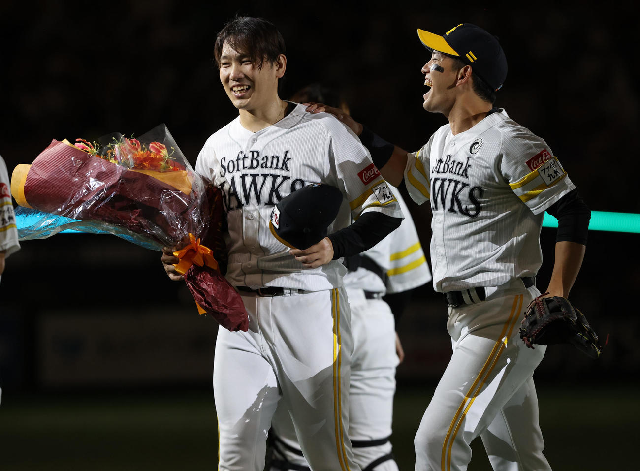 ソフトバンク対西武　ノーヒットノーランを達成した石川（左）は贈られた花束を手に笑顔を見せる。右は栗原（撮影・冨田成美）