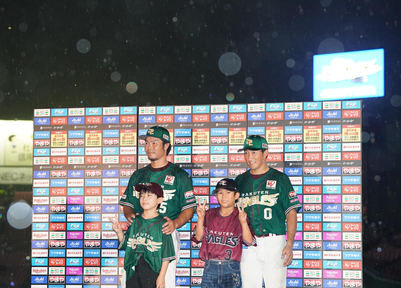 楽天対ロッテ　試合後、雨が降る中、お立ち台で写真に納まる楽天小深田（右端）と島内（撮影・江口和貴）