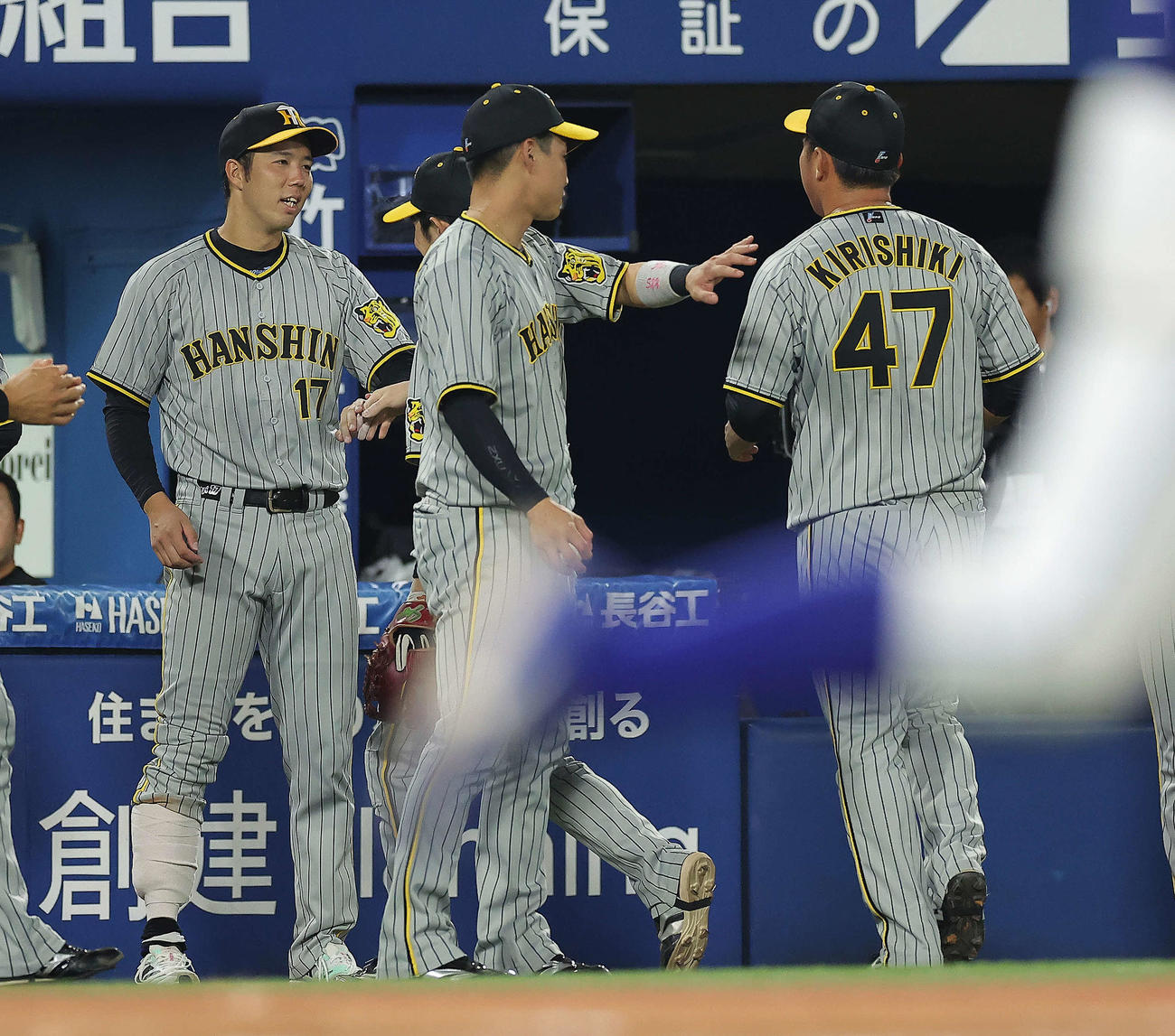 6回裏DeNA攻撃終了、青柳（左）は右すねにサポーターを巻いて桐敷（右）らナインを迎える（撮影・河田真司）