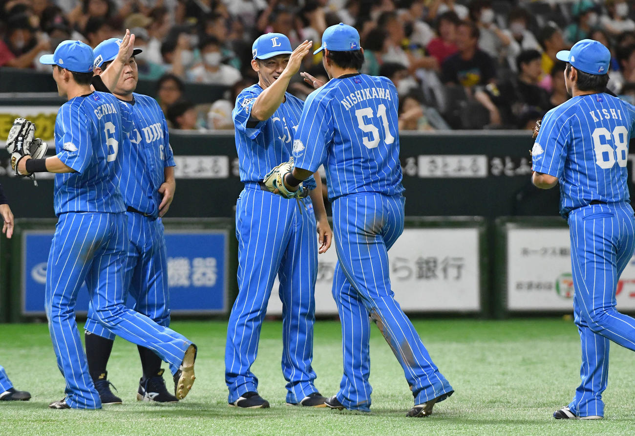 ソフトバンク対西武　ソフトバンクに勝利し、西川（右から2人目）ら西武ナインと笑顔でタッチを交わす栗山（撮影・岩下翔太）