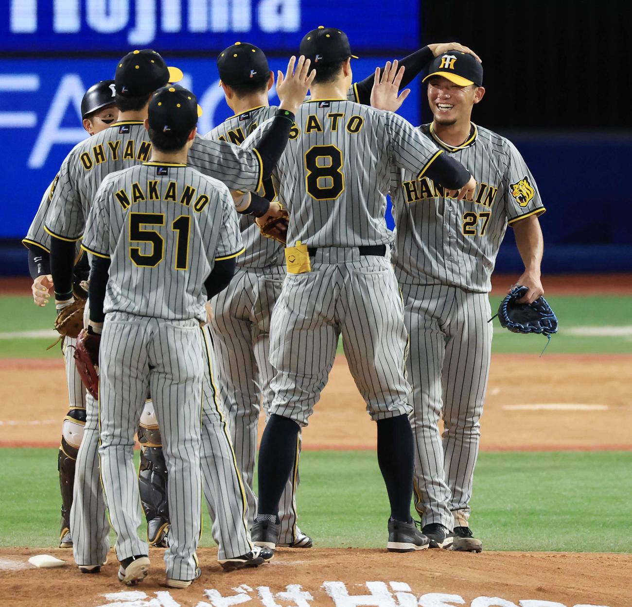DeNA対阪神　9回裏DeNA2死一塁、ソトを右飛に仕留めて完封勝利を決めた伊藤将（右）は笑顔でナインに祝福される（撮影・浅見桂子）