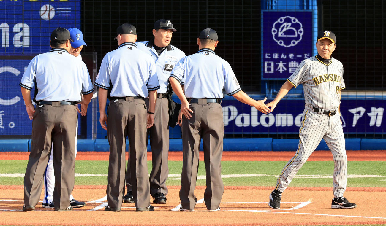 DeNA対阪神　試合前のメンバー最終確認で、審判団と笑顔で握手する阪神岡田監督（右）（撮影・浅見桂子）