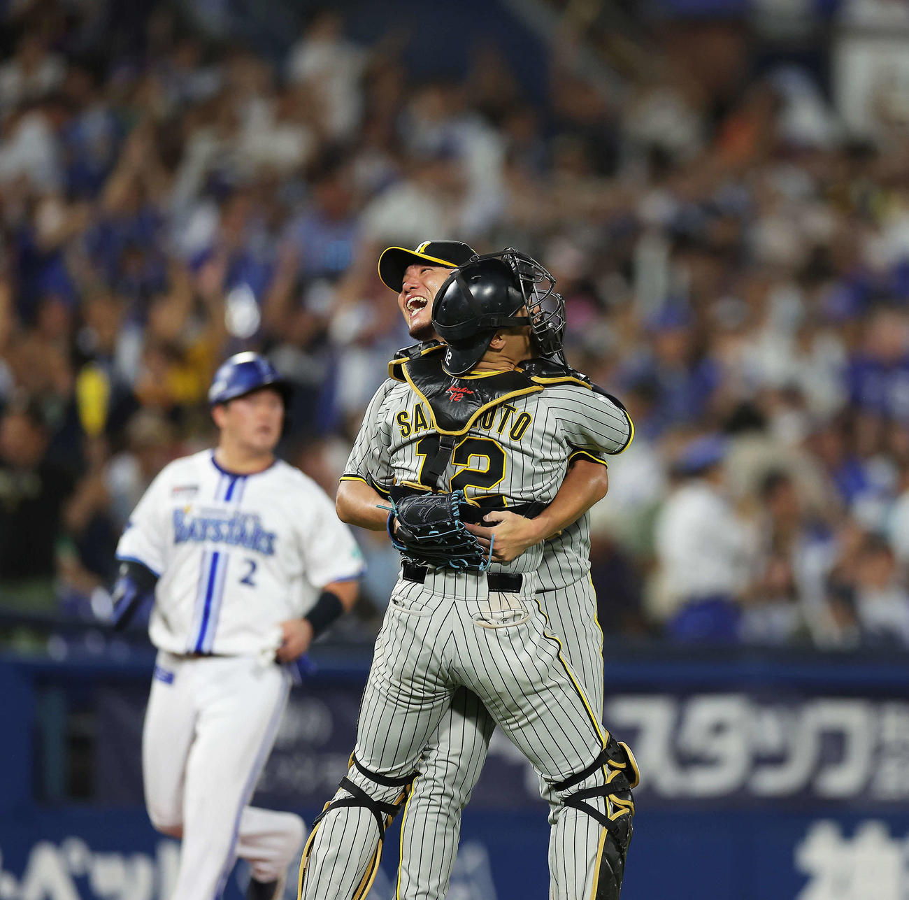DeNA対阪神　最終打者のソトを右飛に抑えDeNAに完封勝利し、坂本（手前）に迎えられ笑顔を見せる伊藤将。後方左は牧（撮影・河田真司）