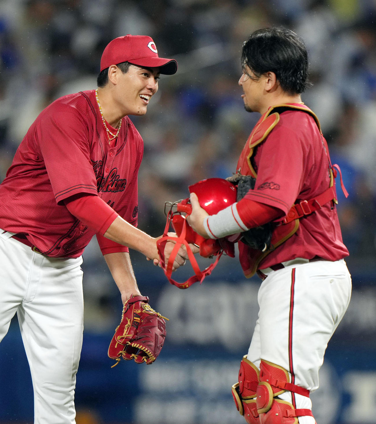 DeNA対広島　試合後、無四球完封勝ちで7勝目を挙げ、会沢（右）と握手を交わす九里（撮影・狩俣裕三）