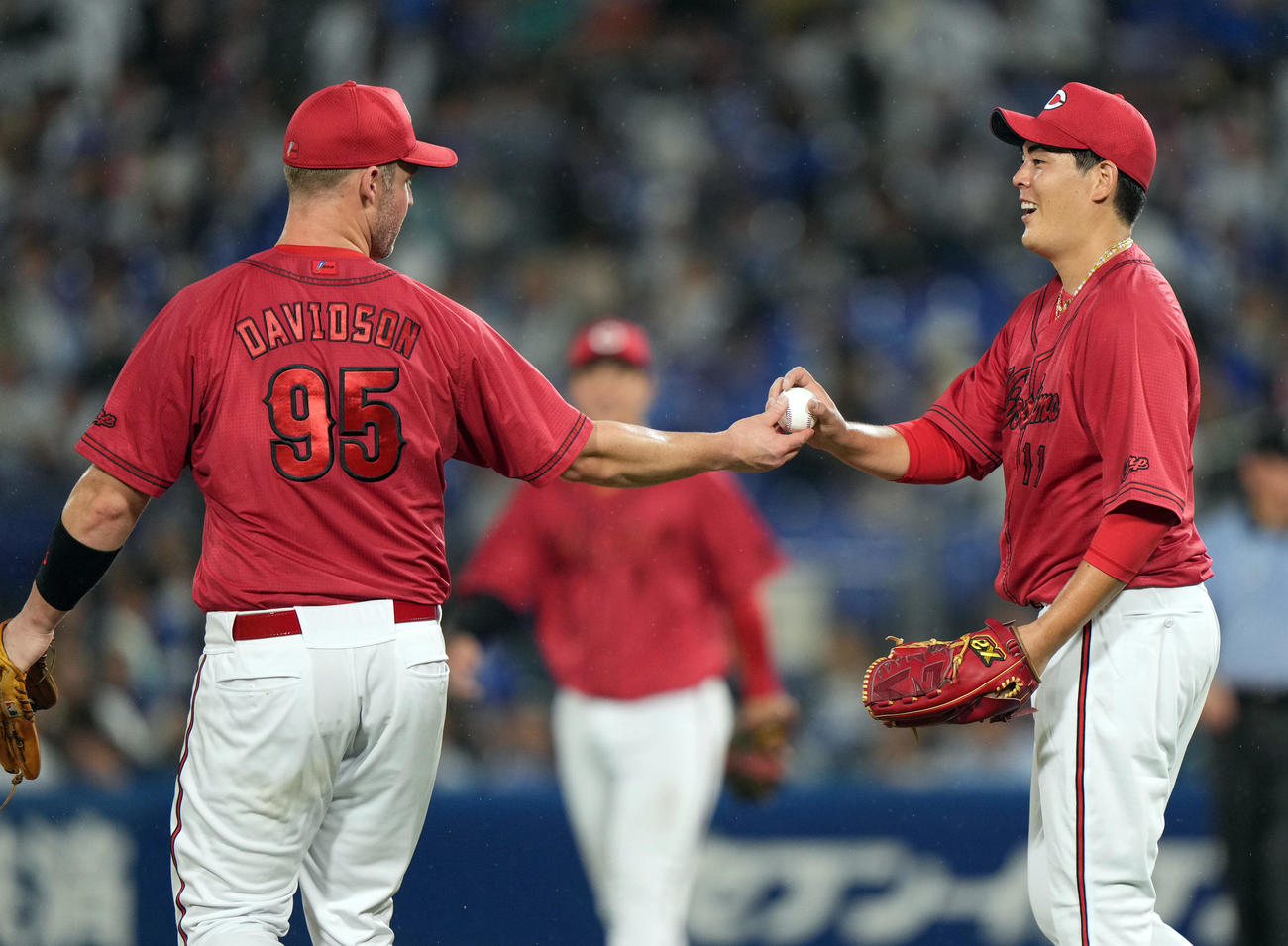 DeNA対広島　試合後、デビッドソン（左）からウイニングボールを受け取り、笑顔を見せる九里（撮影・狩俣裕三）
