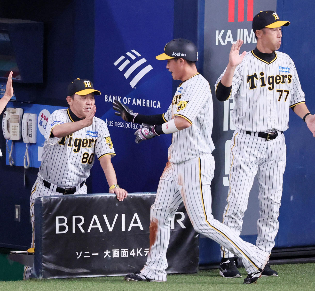阪神対中日　3回裏阪神1死二、三塁、岡田監督（左）は近本の左犠飛で生還した三塁走者木浪を出迎える（撮影・加藤哉）