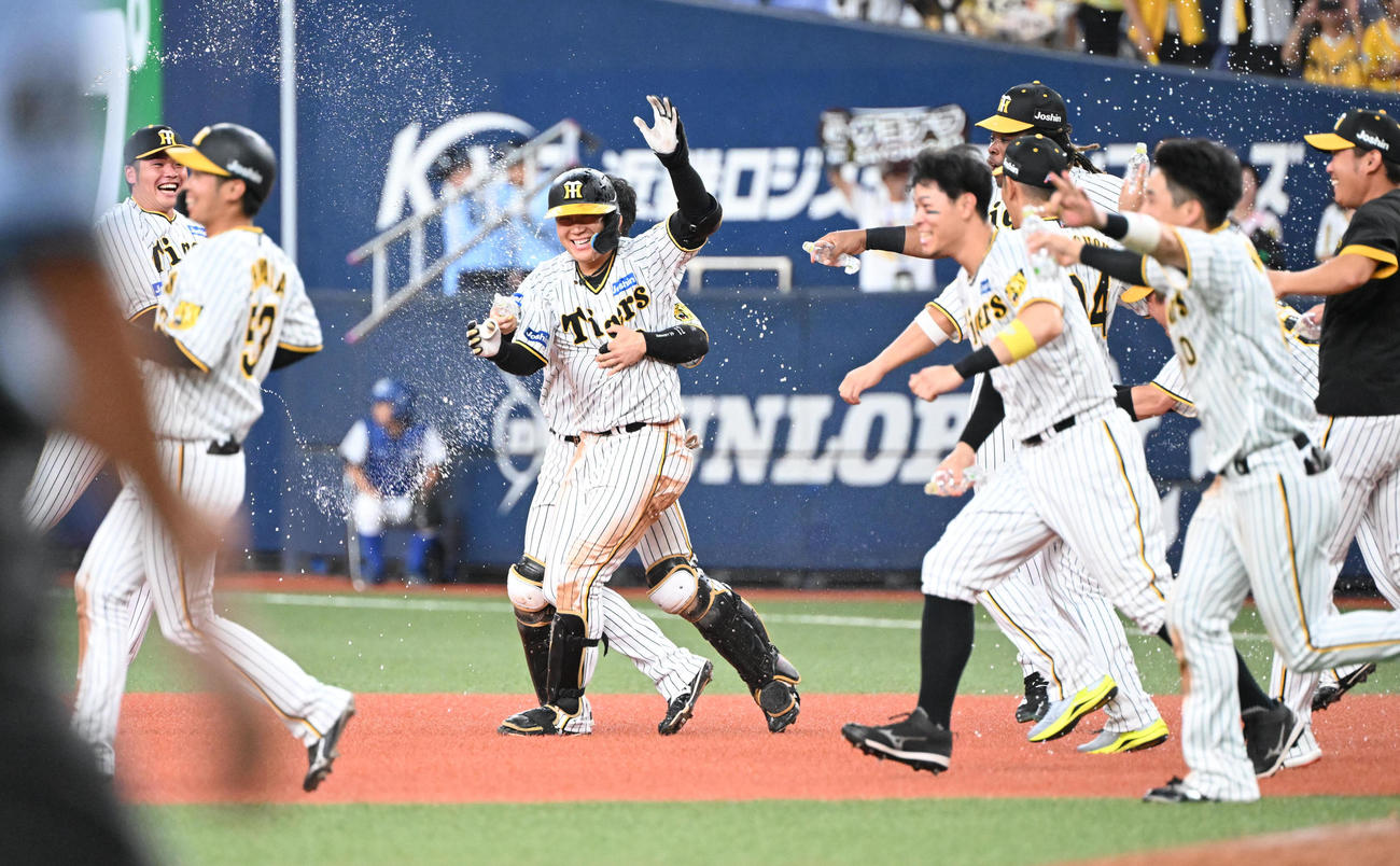 阪神対中日　10回裏阪神2死満塁、左前にサヨナラ打を放った大山はナインから祝福のウオーターシャワーを浴びる（撮影・和賀正仁）