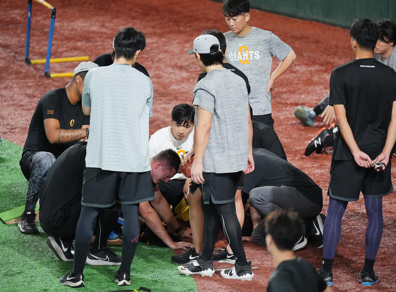 巨人対ヤクルト　試合前練習中、ボールが頭部に当たりうずくまる巨人グリフィン（中央）（撮影・垰建太）