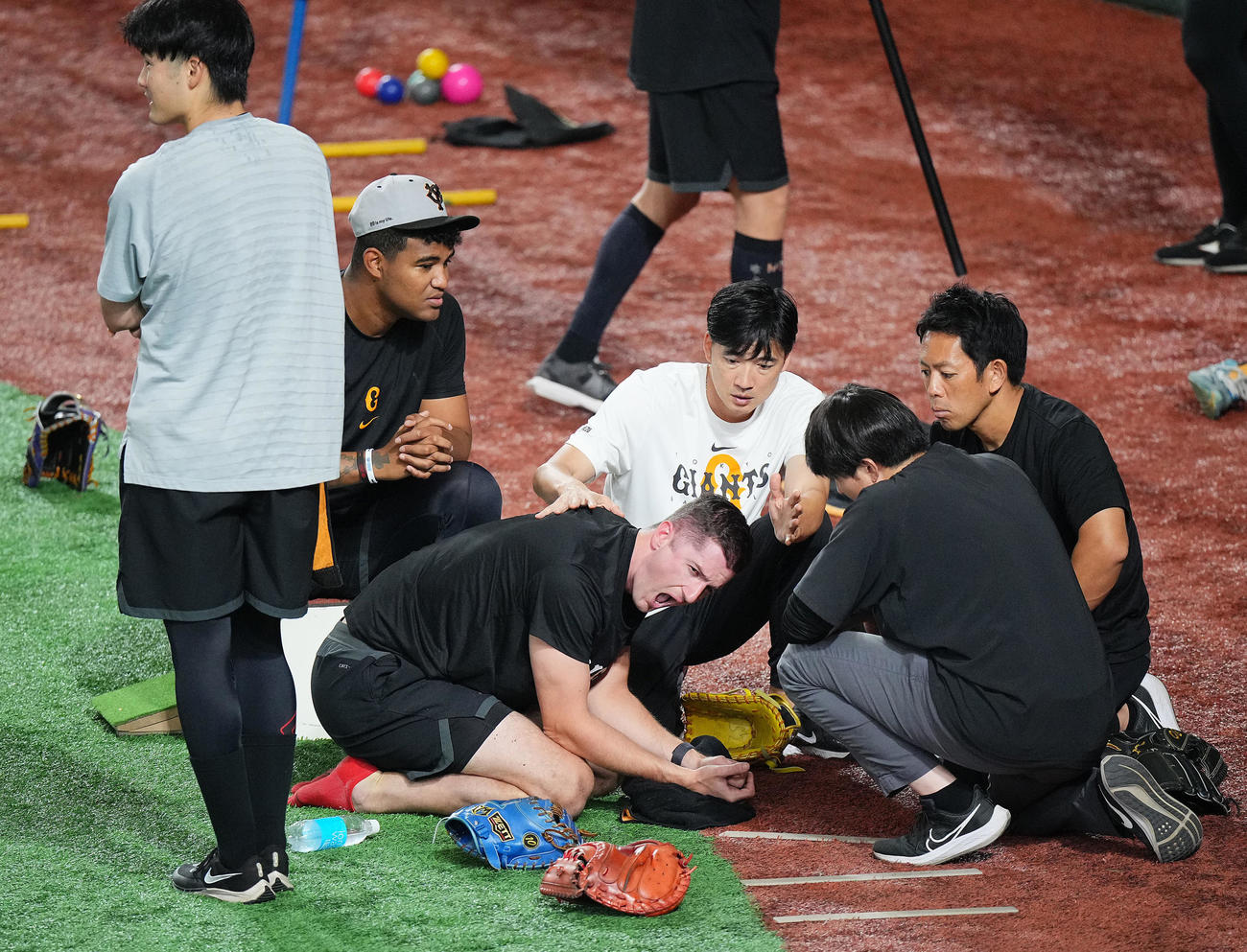 巨人対ヤクルト　試合前練習中、ボールが頭部に当たりうずくまる巨人グリフィン（中央）（撮影・垰建太）