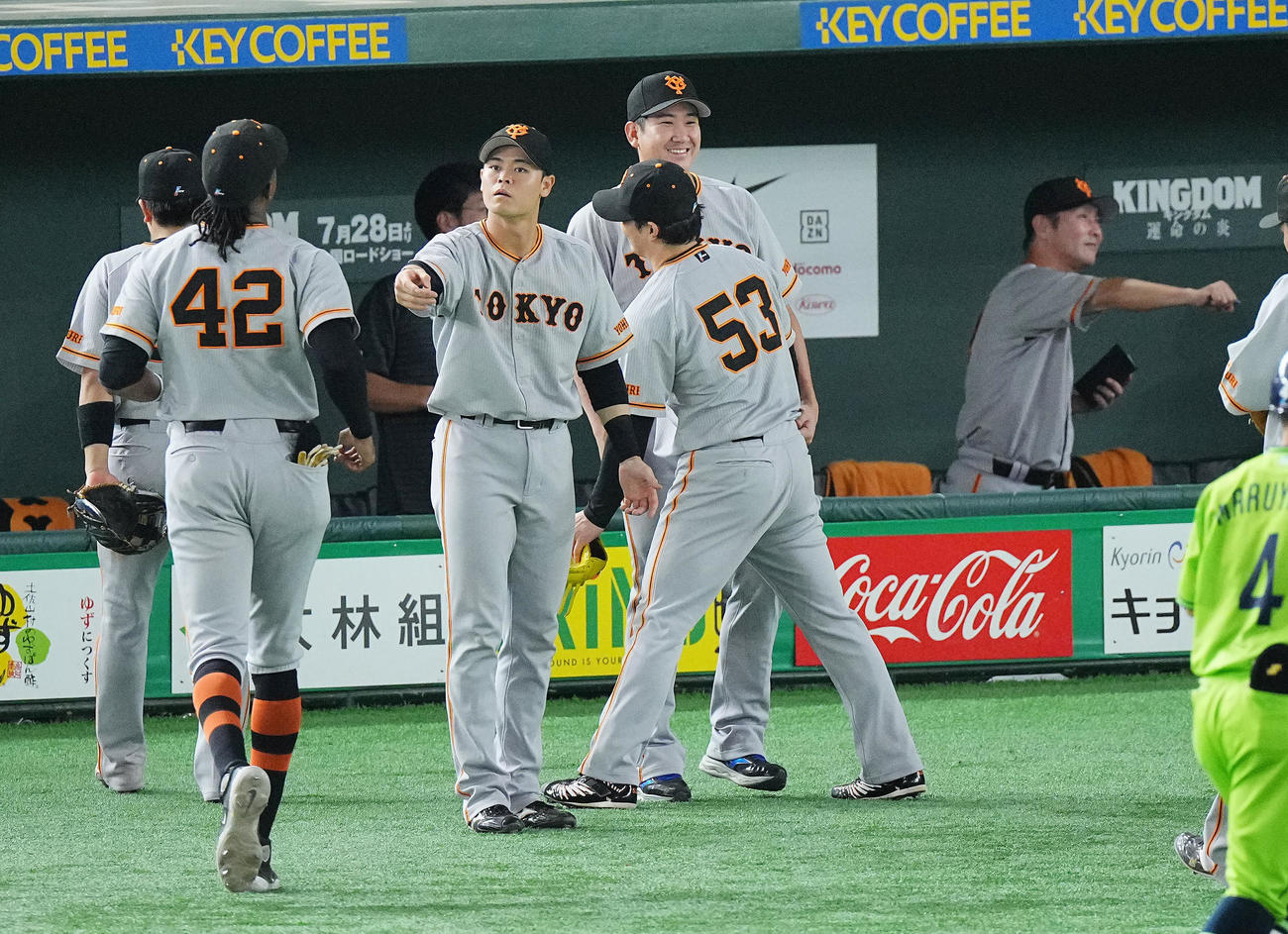 巨人対ヤクルト　8回表ヤクルトの攻撃を無失点に抑えた巨人高梨（53番）を笑顔で出迎える菅野（中央）(撮影・垰建太）