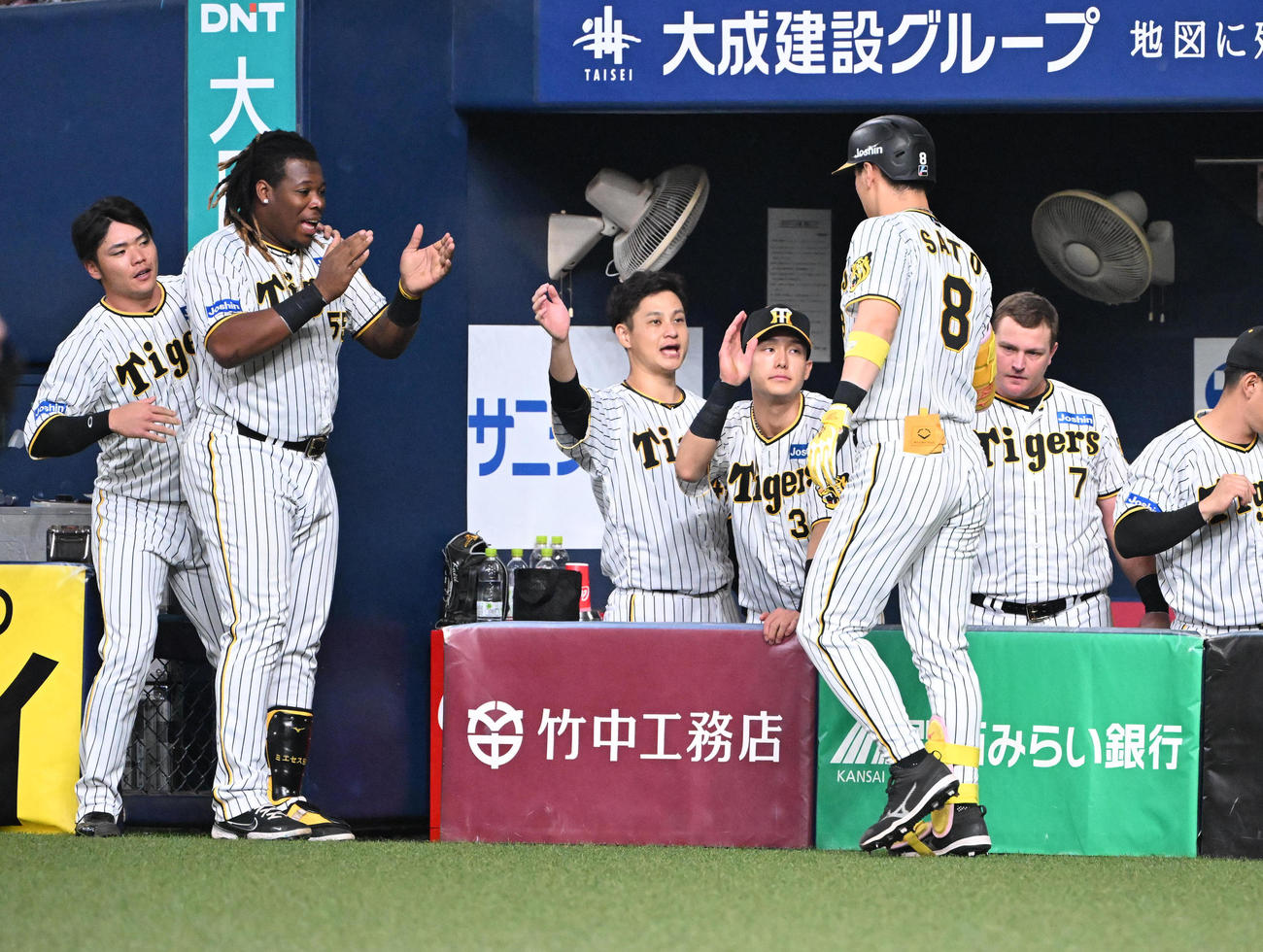 阪神対中日　4回裏阪神無死、右中間にソロ本塁打を放った佐藤輝はナインの出迎えを受ける（撮影・和賀正仁）