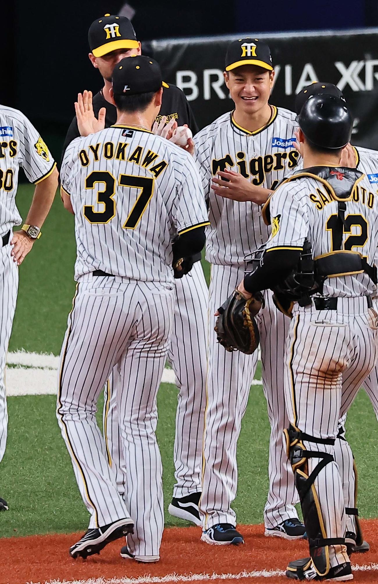 阪神対中日　9勝目を挙げた大竹（右から2人目）は、及川から勝利球を受け取り笑顔を見せる（撮影・上田博志）