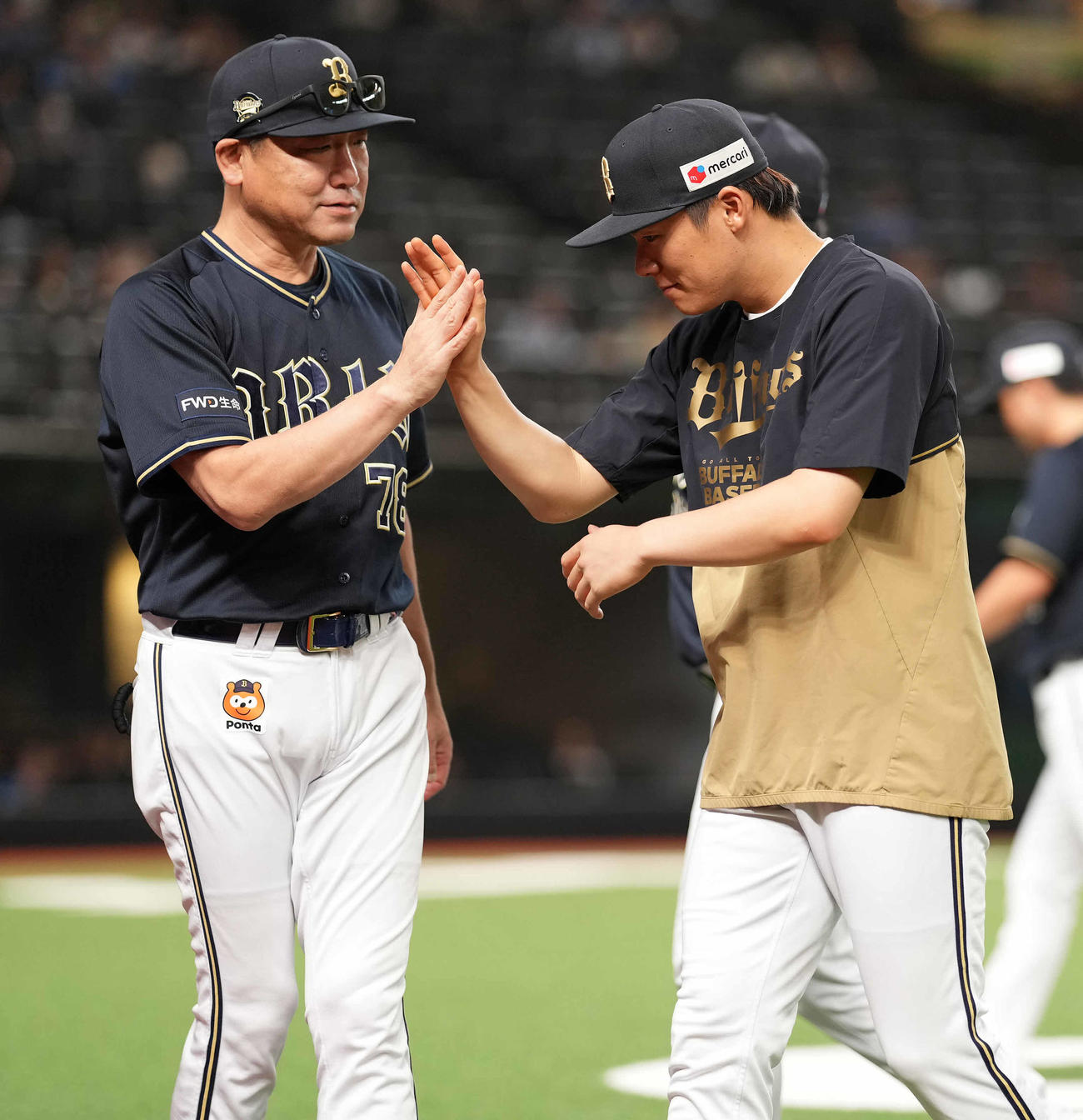 西武対オリックス　7回無失点で12勝目のオリックス山本（右）は中嶋監督とタッチを交わす（撮影・鈴木みどり）