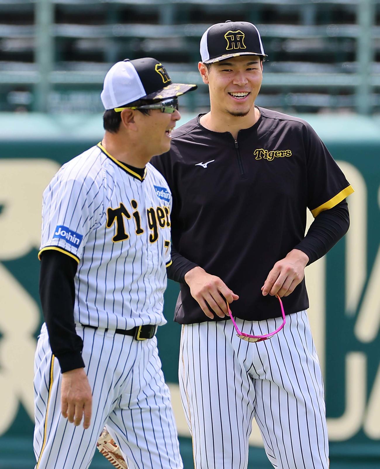 平田ヘッドコーチ（左）と談笑する佐藤輝（撮影・上田博志）