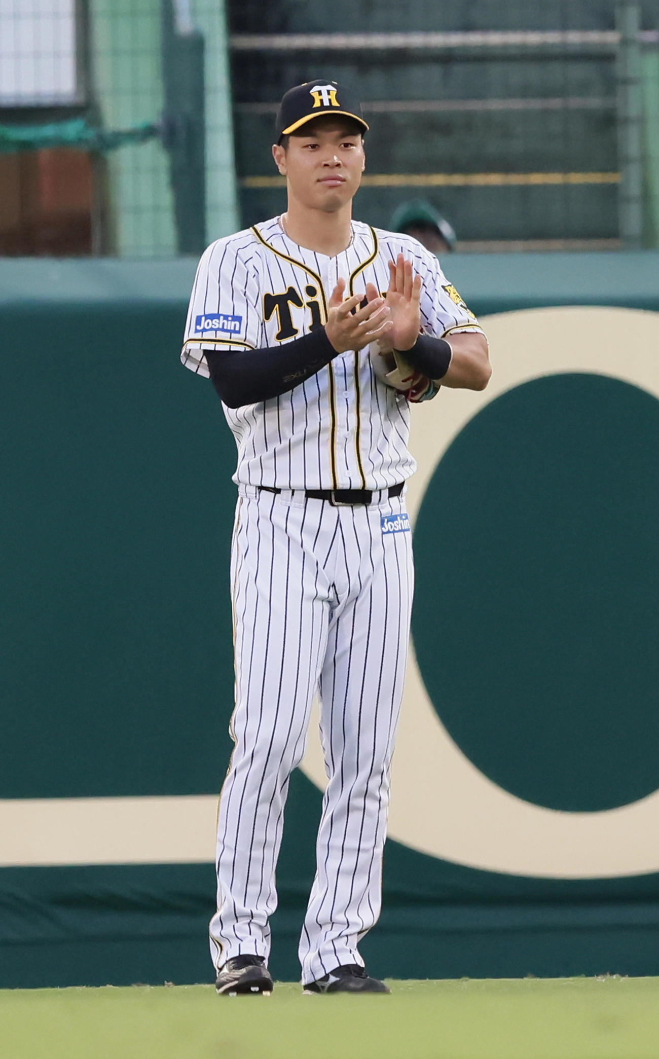 阪神対巨人　始球式を行った「ももいろクローバーZ」の高城れにに拍手を送る阪神佐藤輝（2021年9月5日撮影）