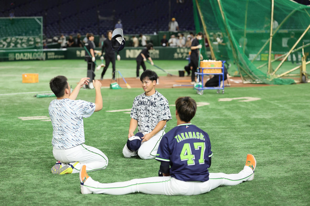 練習中、空中くるりんぱに成功するヤクルトの大西（左）と丸山和（中央）。右は高橋（撮影・足立雅史）