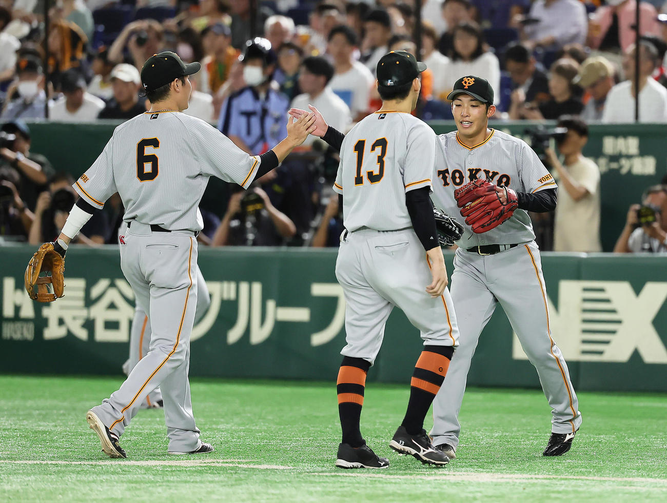 巨人対ヤクルト　6回表ヤクルト2死一、二塁、サンタナを左飛に仕留めた赤星（右）は野手陣とタッチを交わす（撮影・足立雅史）
