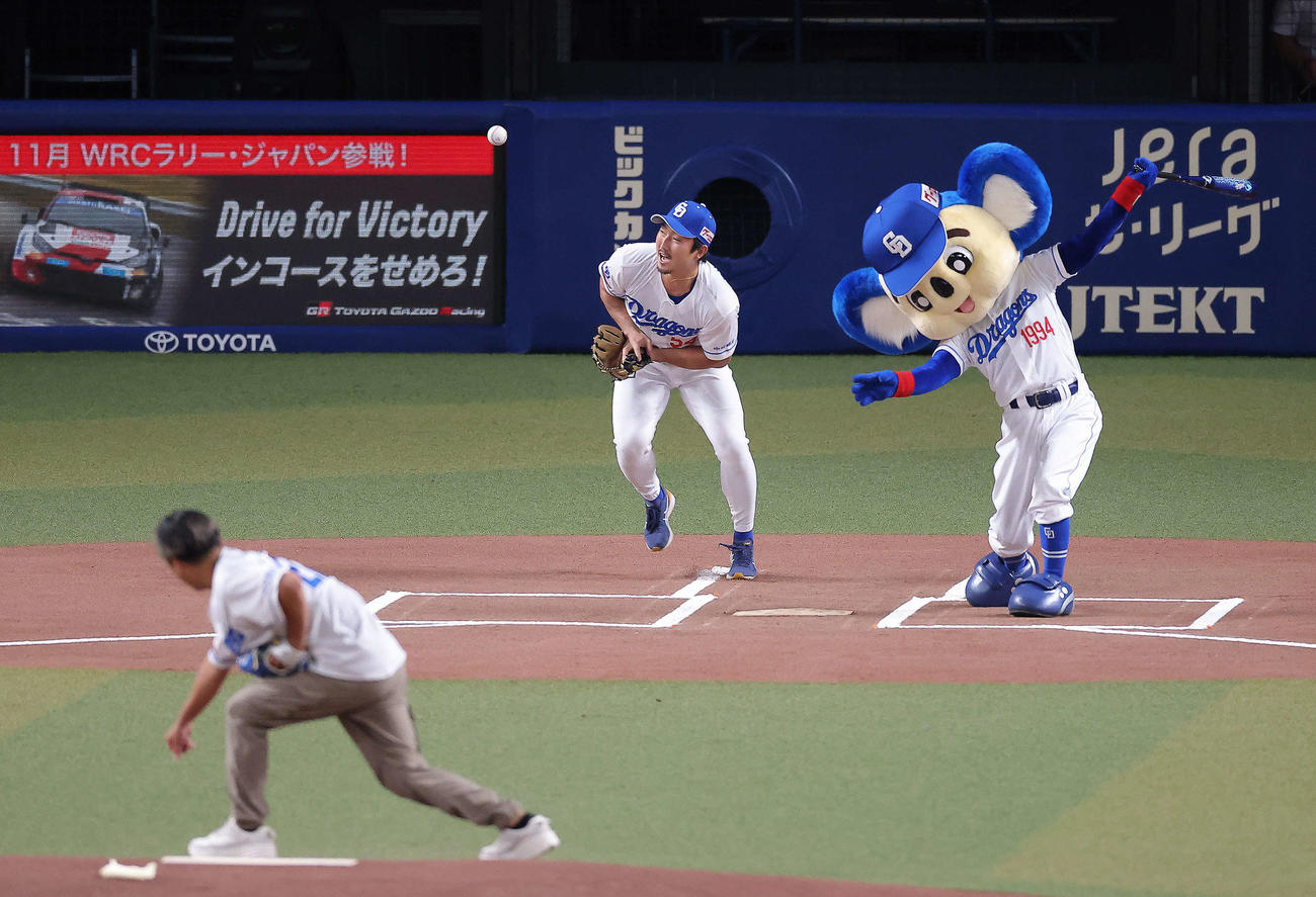 中日対DeNA　試合開始前、セレモニアルピッチで投球するDa－iCE大野雄大の球にスイングするドアラ。捕手藤嶋（撮影・河田真司）