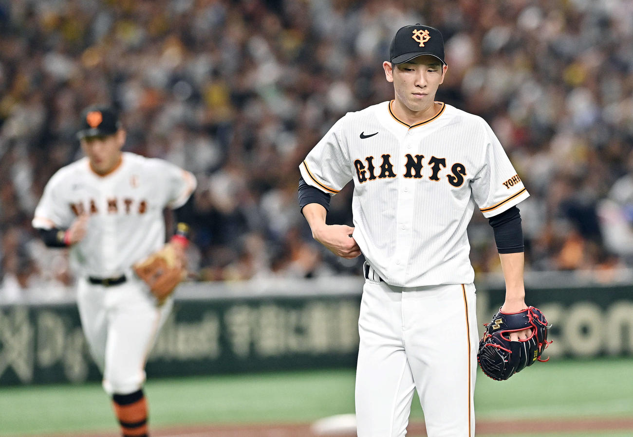 巨人対阪神　3回表、先制を許した巨人先発の戸郷（手前）は浮かない表情でベンチへ引き揚げる（撮影・滝沢徹郎）
