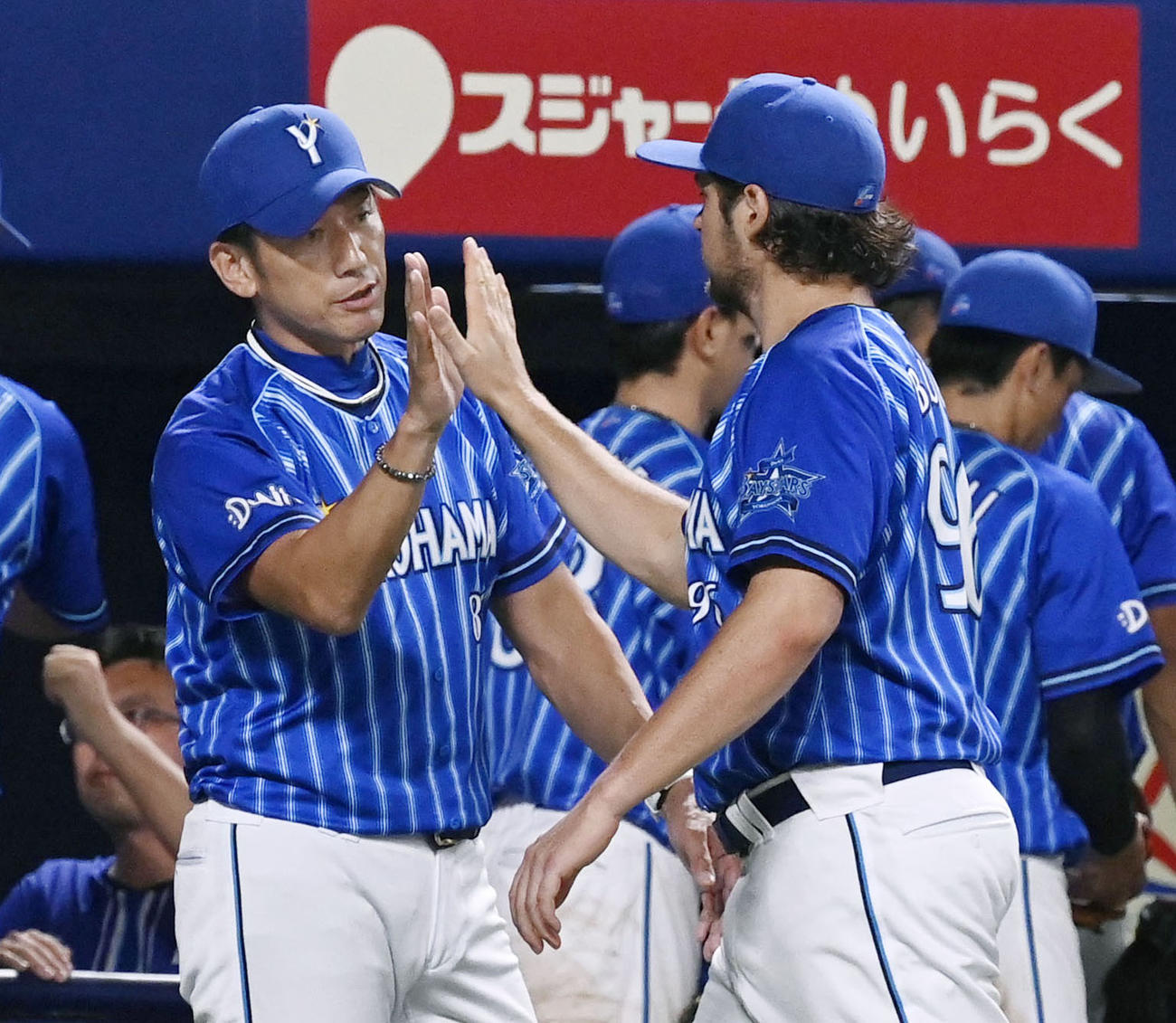 中日に快勝し、10勝目を挙げたバウアー（右）とタッチするDeNAの三浦監督＝バンテリンドーム（共同）