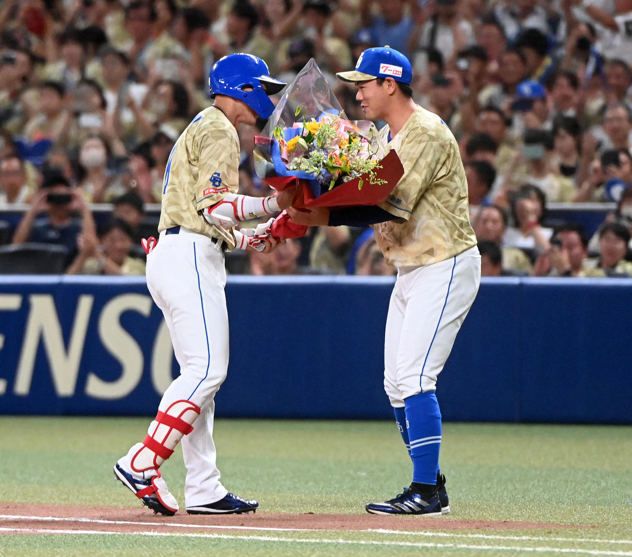 中日対DeNA 3回裏中日1死一塁、大島（左）は中前打を放ち2000本安打を達成、高橋周から花束を受け取る（撮影・前岡正明）