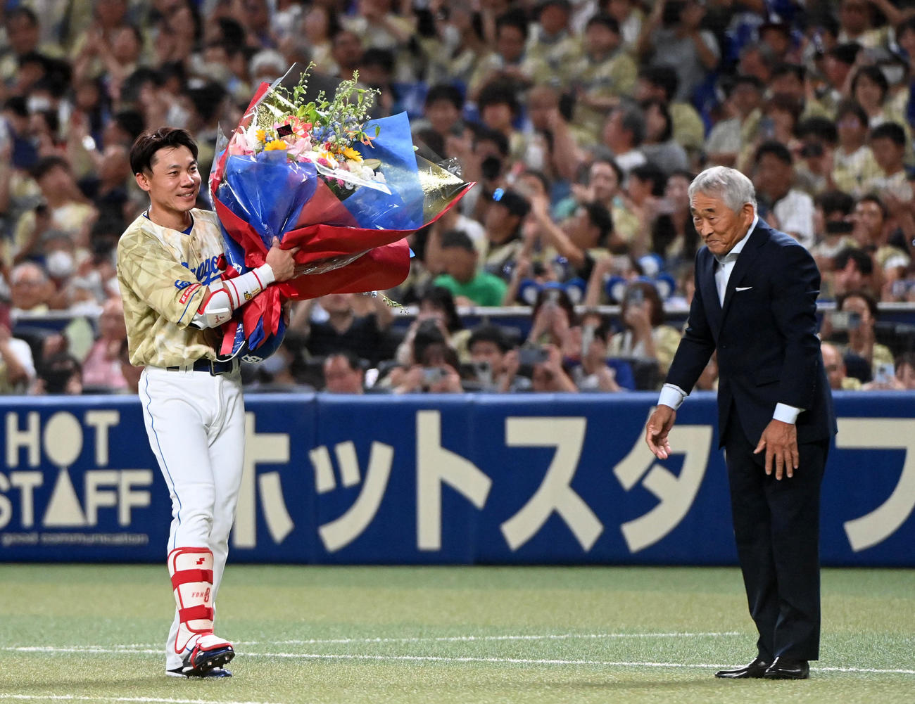 中日対DeNA 3回裏中日1死一塁、大島は中前打を放ち2000本安打を達成享栄高の柴垣旭延元監督から花束を受け取る（撮影・前岡正明）