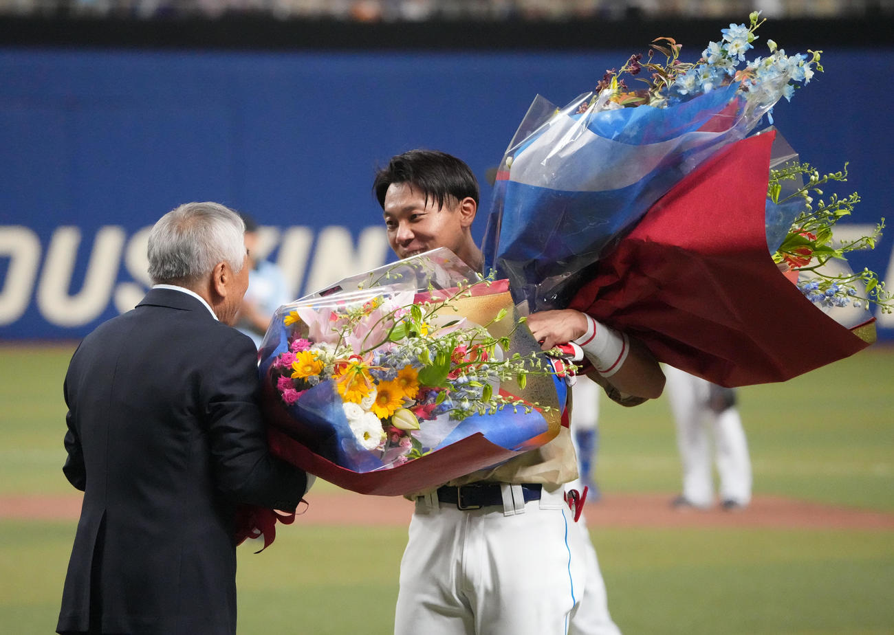 中日対DeNA 3回裏中日1死一塁、中前安打を放ち通算2000本安打を達成し元享栄高校野球部監督の柴垣旭延氏から花束を受け取る大島（右）（撮影・森本幸一）