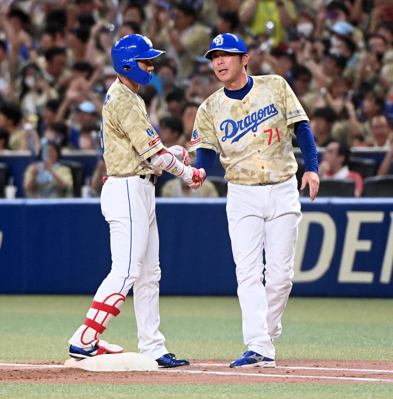 中日対DeNA 3回裏中日1死一塁、大島は中前打を放ち2000本安打を達成、荒木コーチの祝福を受ける（撮影・前岡正明）
