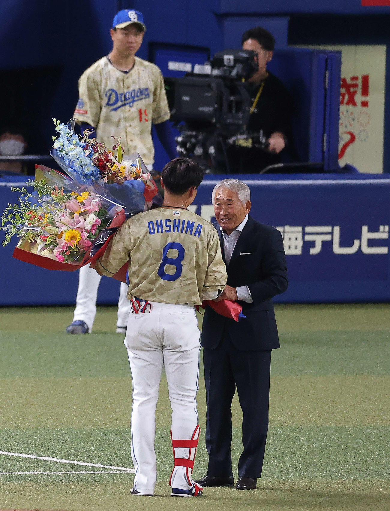 中日対DeNA 3回裏、通算2000安打を達成した大島（左）を祝福する享栄高元監督の柴垣氏（撮影・河田真司）