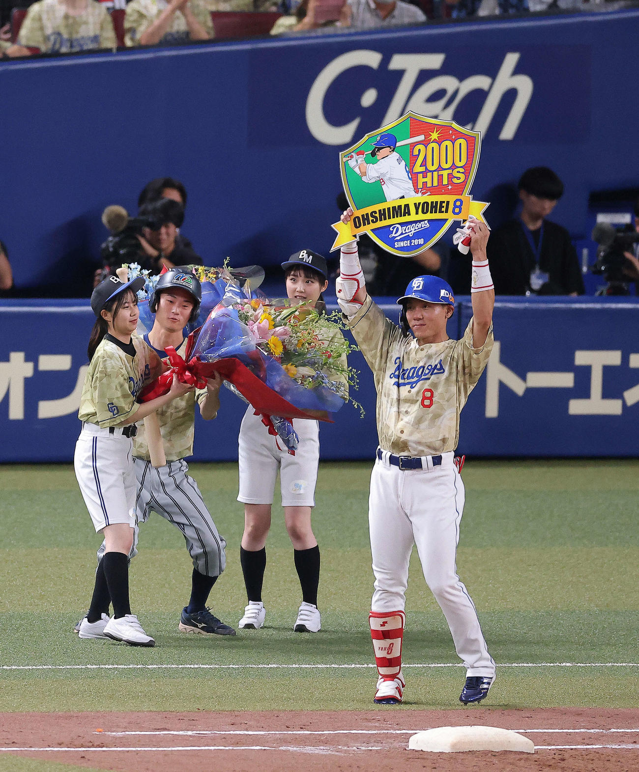 中日対DeNA 3回裏中日1死一塁、通算2000安打となる中前打を放ち、メモリアルボードを手に観客の祝福に応える大島（撮影・河田真司）