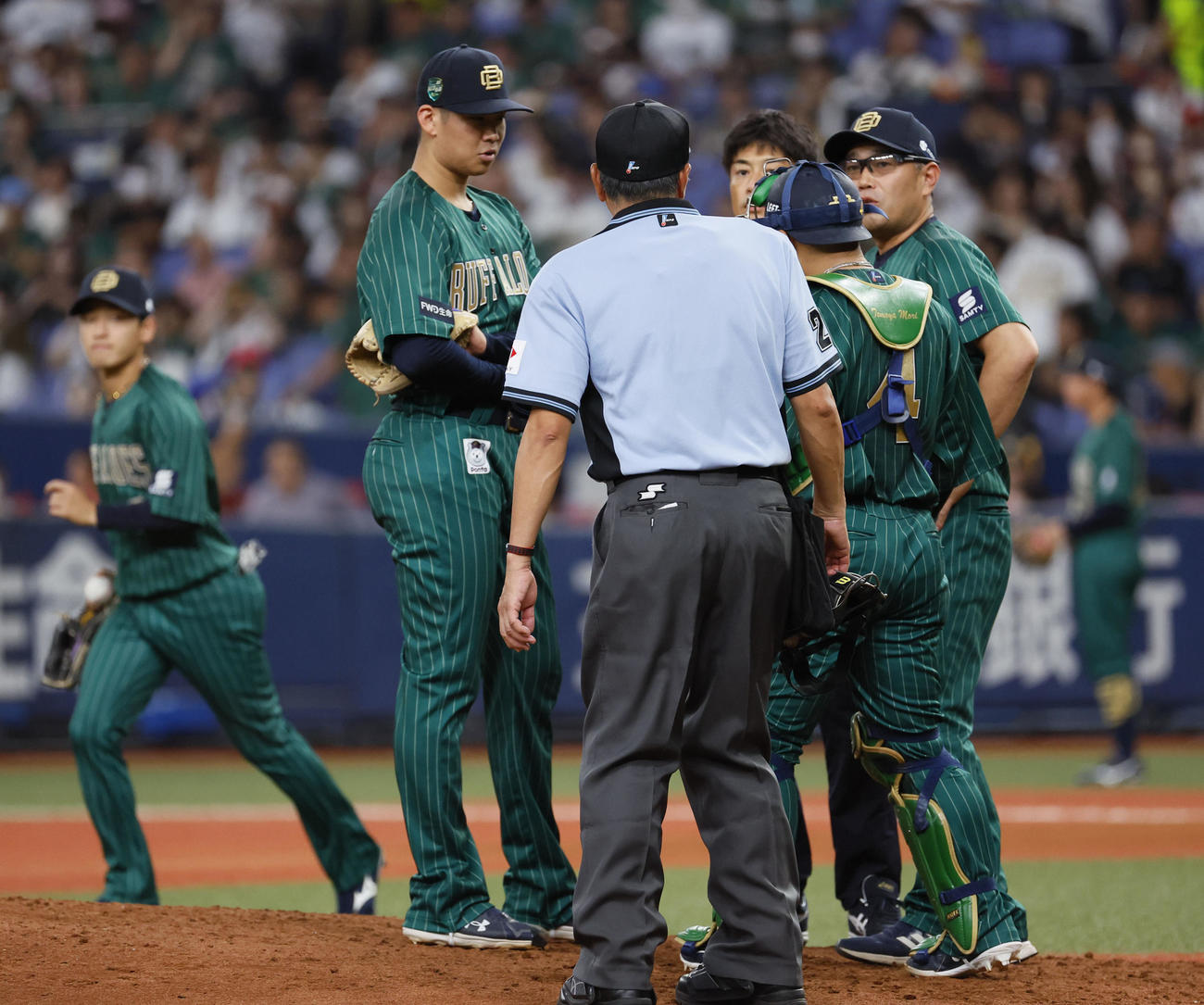オリックス対ロッテ　6回表のマウンドに上がるも、治療に向かいそのまま降板するオリックス山下（左から2人目）（撮影・藤尾明華）