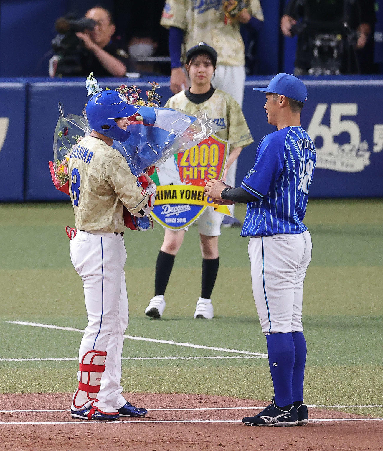 中日対DeNA 3回裏、通算2000安打を達成した大島（左）は、京田から祝福の花束を受け取る（撮影・河田真司）