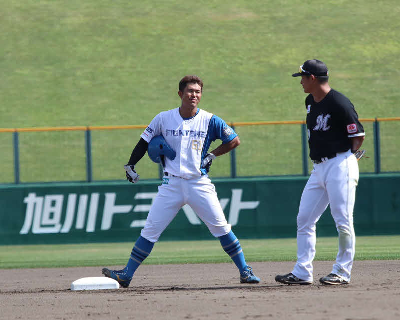 日本ハム対ロッテ　2回に出塁し、試合の中断中にロッテのスタッフと談笑する日本ハム今川（左）（撮影・永野高輔）