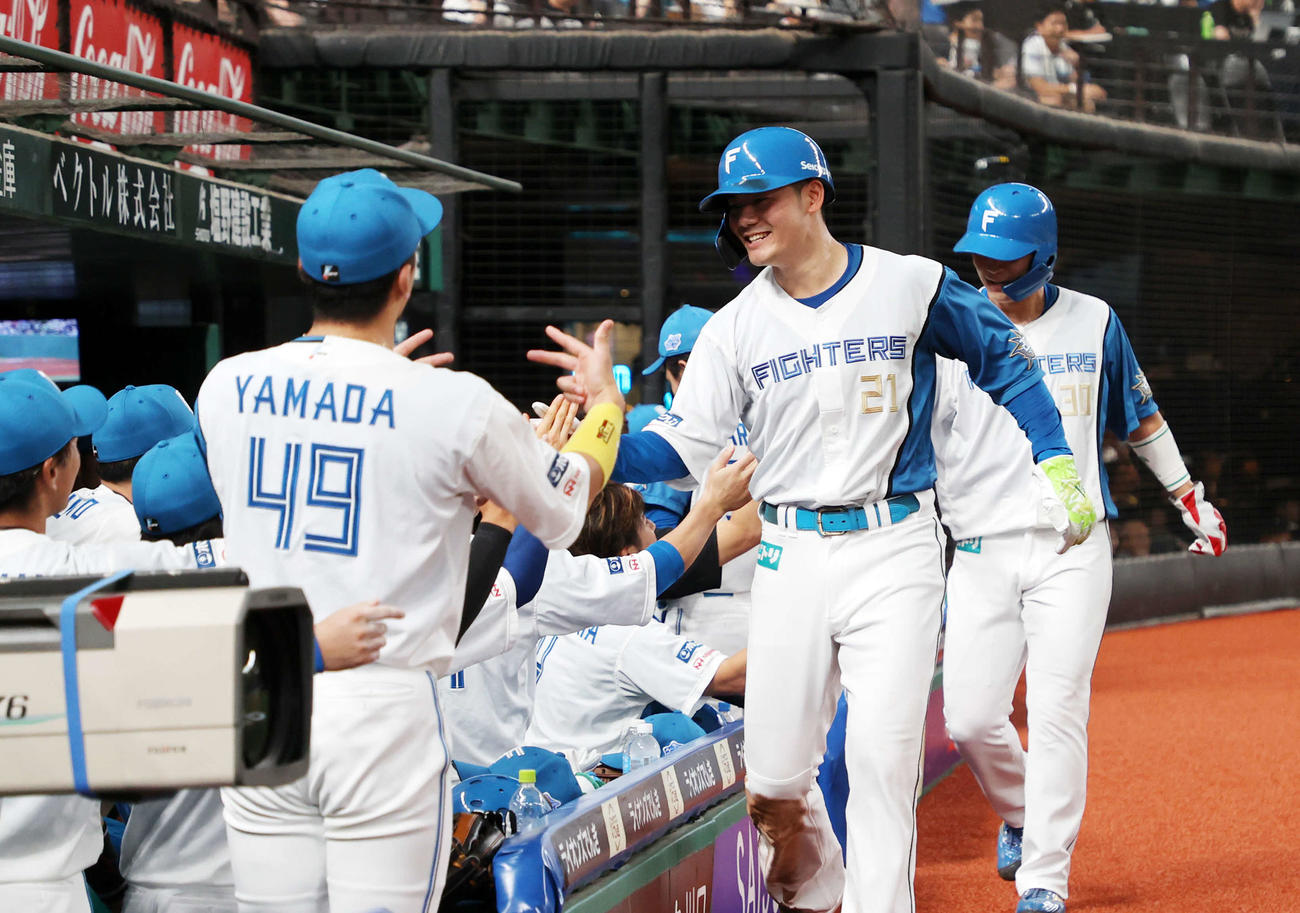 西武対日本ハム　2回表日本ハム2死二、三塁、マルティネスの左前適時打で清宮（中央）が生還しベンチ前で笑顔を見せる（撮影・鈴木正人）