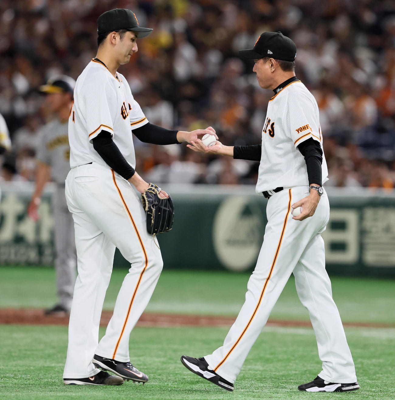 巨人対阪神　5回表阪神無死一、二塁、打者ノイジーを迎えたところで降板する横川（左）は原監督へボールを手渡した（撮影・加藤哉）