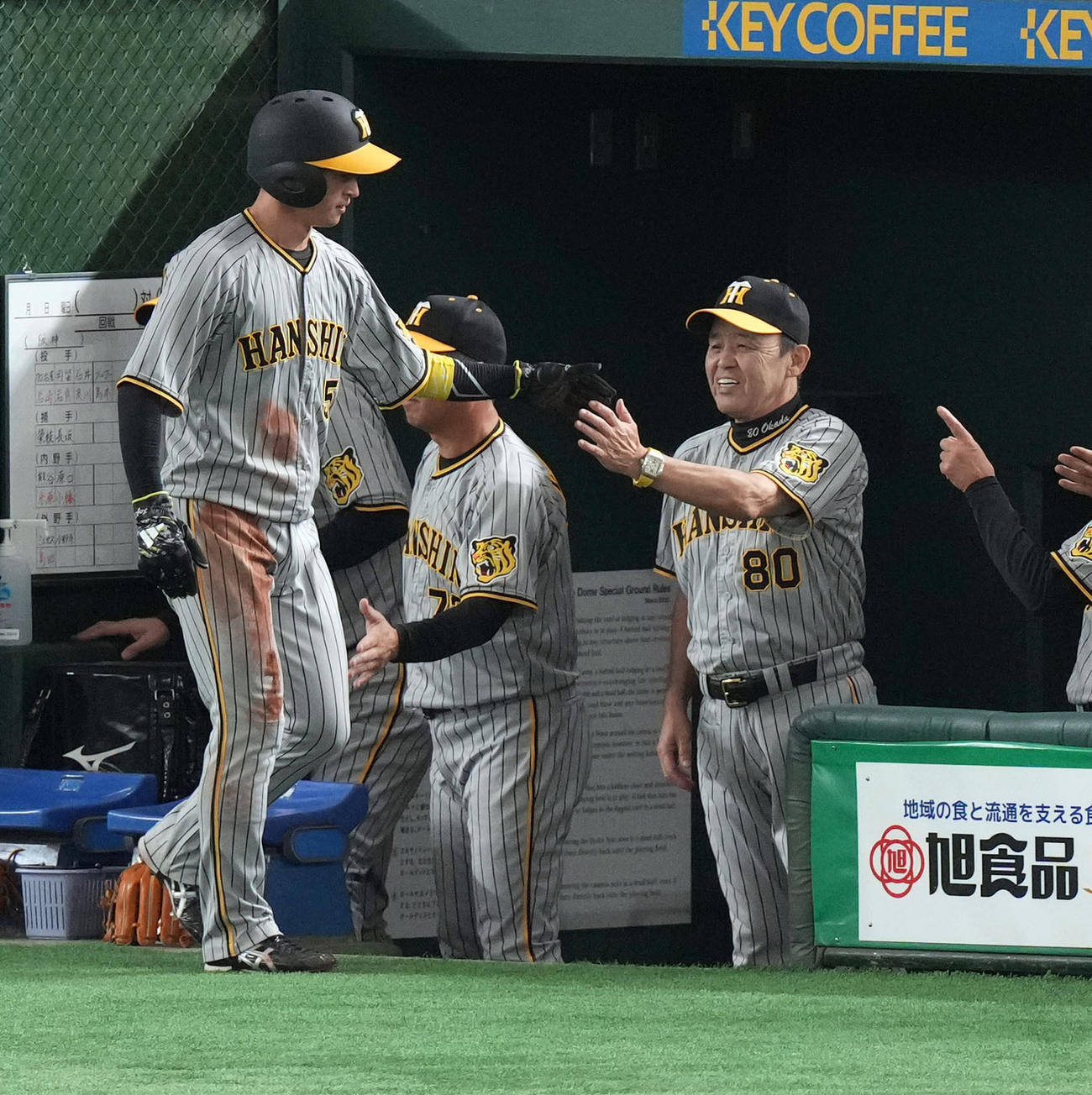 巨人対阪神　3回表阪神1死二塁、相手のミスから生還した近本（左）を笑顔で迎える岡田監督（撮影・狩俣裕三）