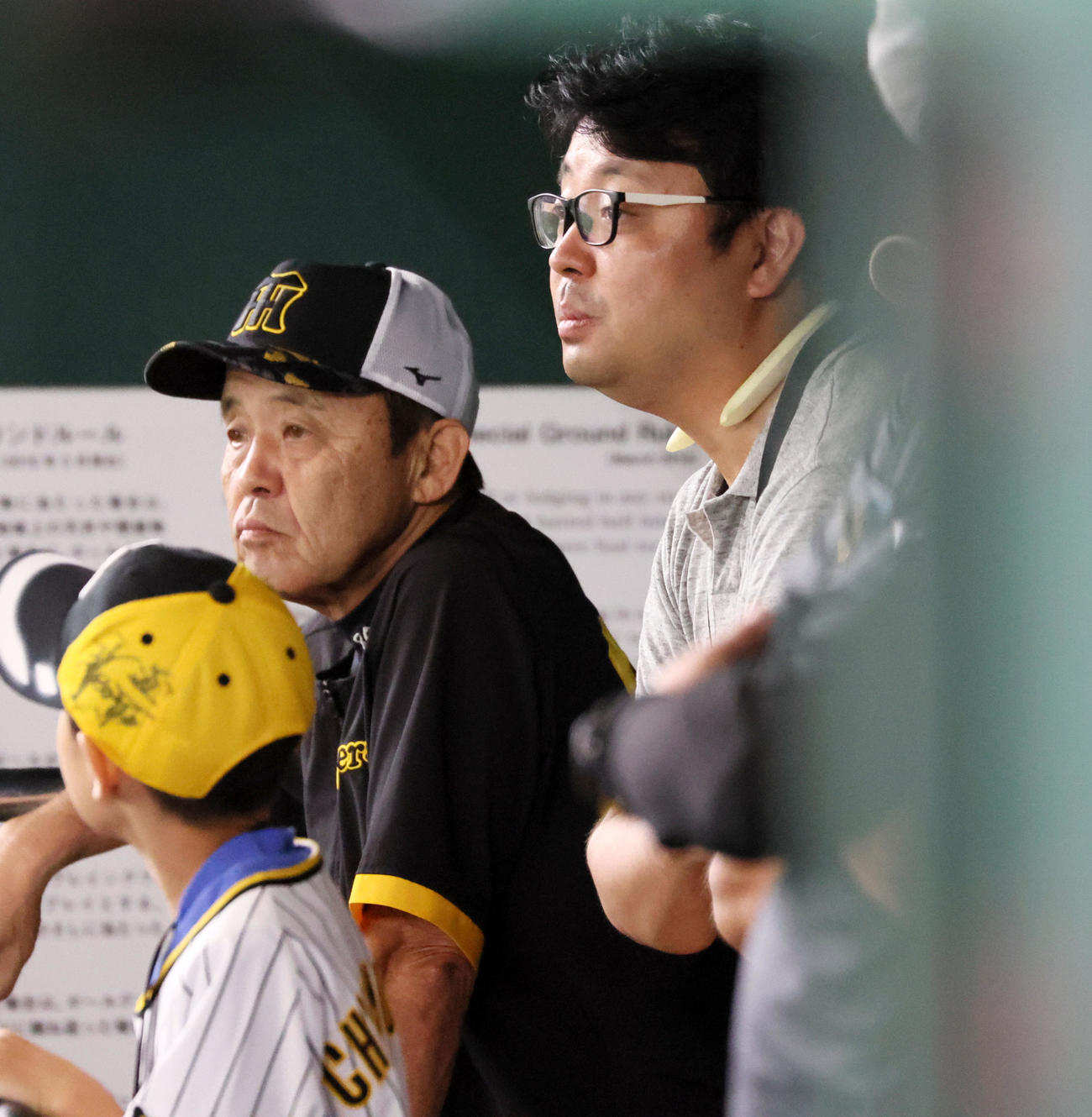 巨人対阪神　ベンチで見学する岡田監督（左）の息子・陽集さん（撮影・加藤哉）