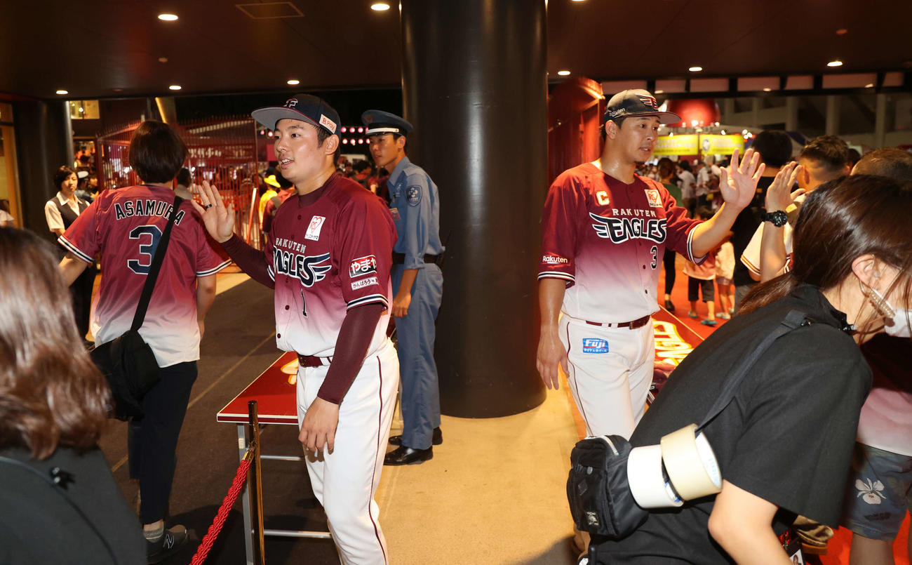 楽天対ソフトバンク　試合後、ファンを見送るイベントでハイタッチする楽天松井裕（左）と浅村（撮影・浅見桂子）
