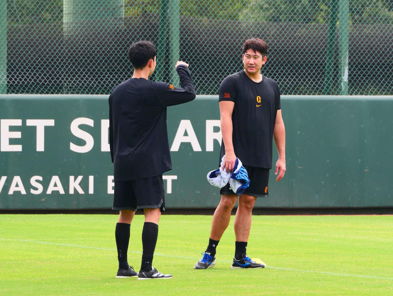 練習中に会話をする巨人山崎伊（左）と菅野（撮影・上田悠太）