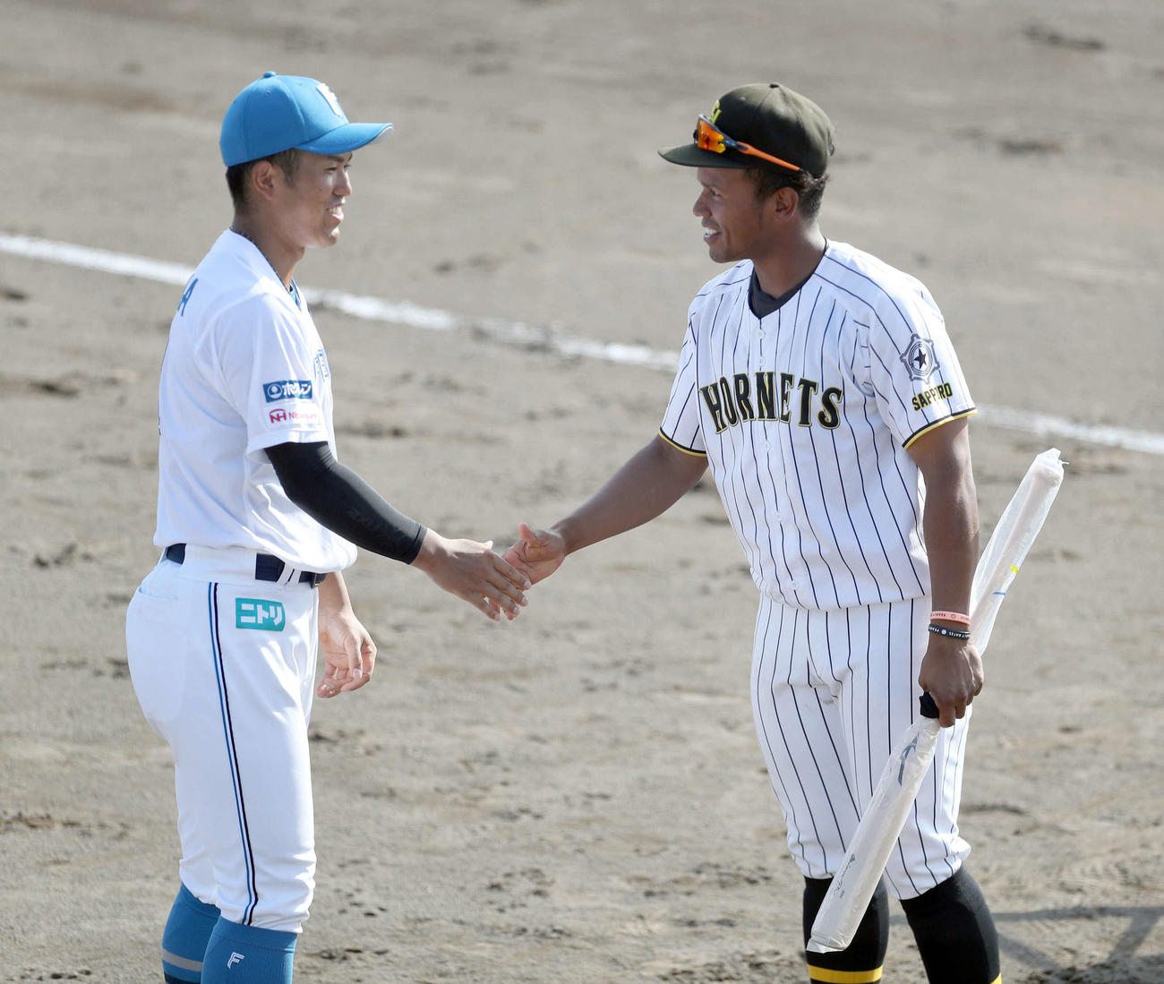 試合終了後、北海道社会人・大学選抜の選手にバットをプレゼントする日本ハム今川（撮影・佐藤翔太）