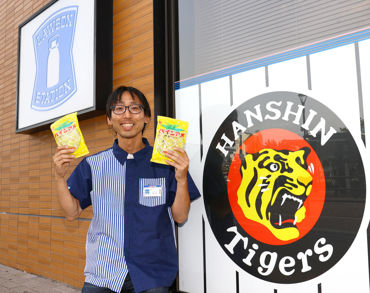 パインアメを手に笑顔を見せるローソンHA阪神甲子園西口店の前田店長（撮影・上山淳一）