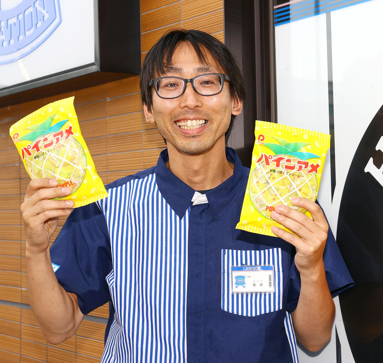 パインアメを手に笑顔を見せるローソンHA阪神甲子園西口店の前田店長（撮影・上山淳一）