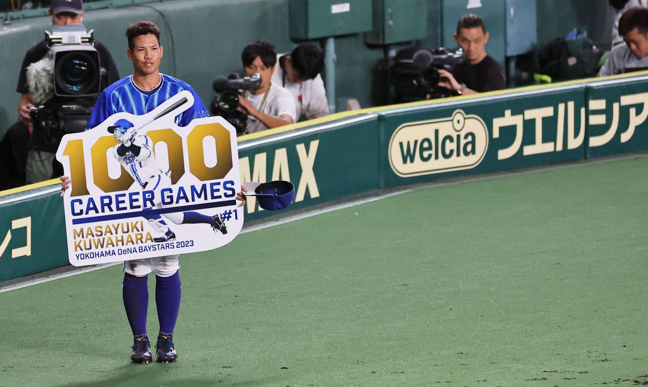 阪神対DeNA 5回、1000試合出場を果たした桑原将志はパネルを手に笑顔見せる（撮影・上田博志）