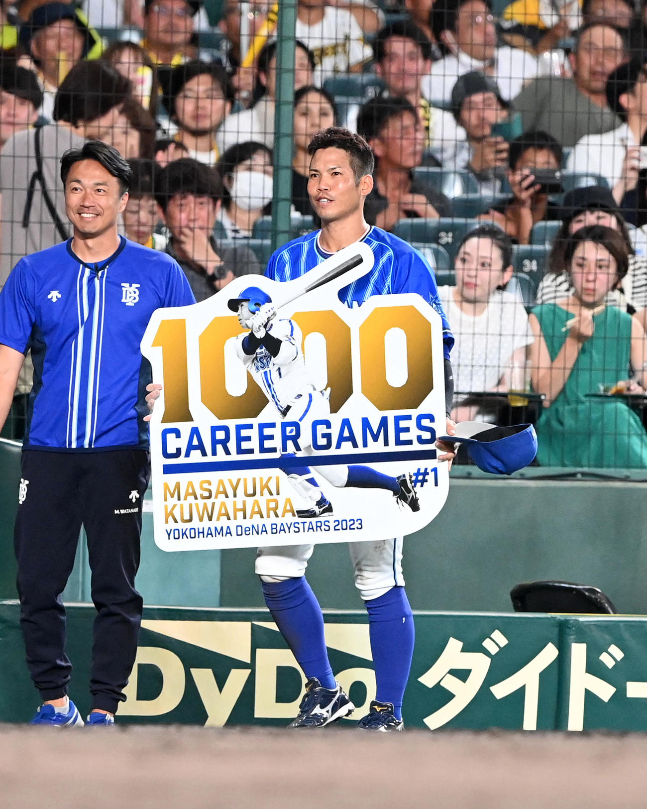 阪神対DeNA 1000試合出場を達成したDeNA桑原は記念ボードを手に笑顔を見せる（撮影・前岡正明）
